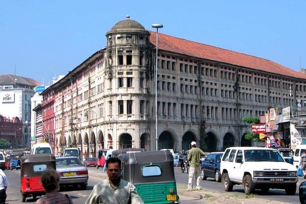Colombo street scene showing colonial-era buildings alongside modern billboards and traffic, symbolising Sri Lanka’s layered identity and inherited hierarchies.